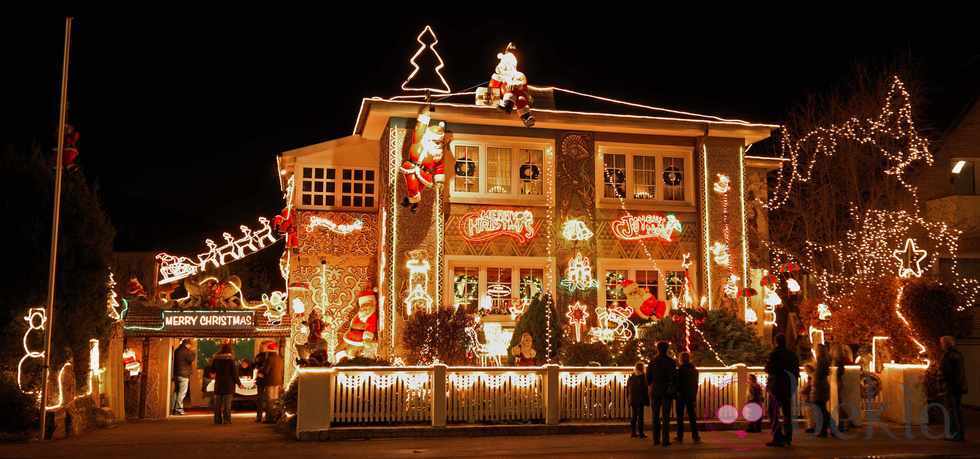 People walking in front of a seasonaly decorated house in the Niendorf district of Hamburg, northern Germany, admire the colorful Christmas illumination on Saturday evening, Nov. 28, 2009.
