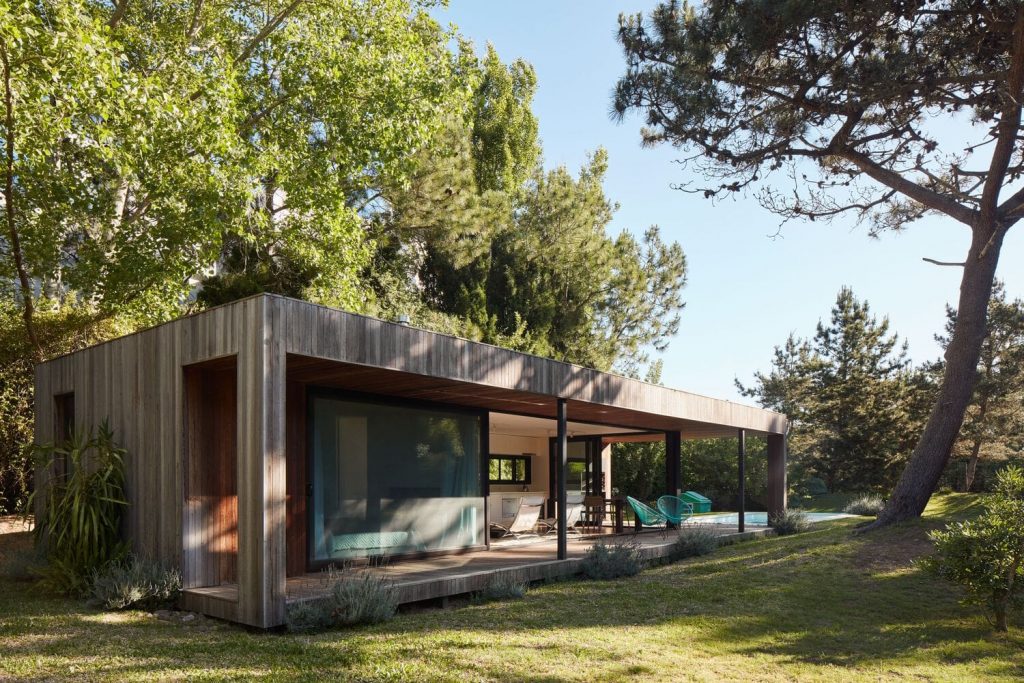 Fachada de casa con estructura de madera vista de costado