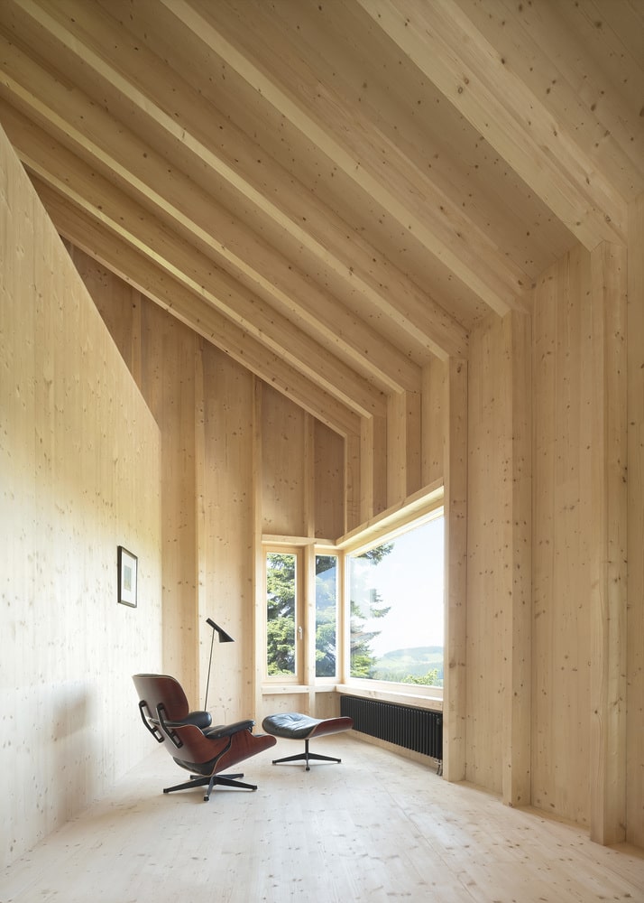 Interior de casa de madera con una ventana en esquina